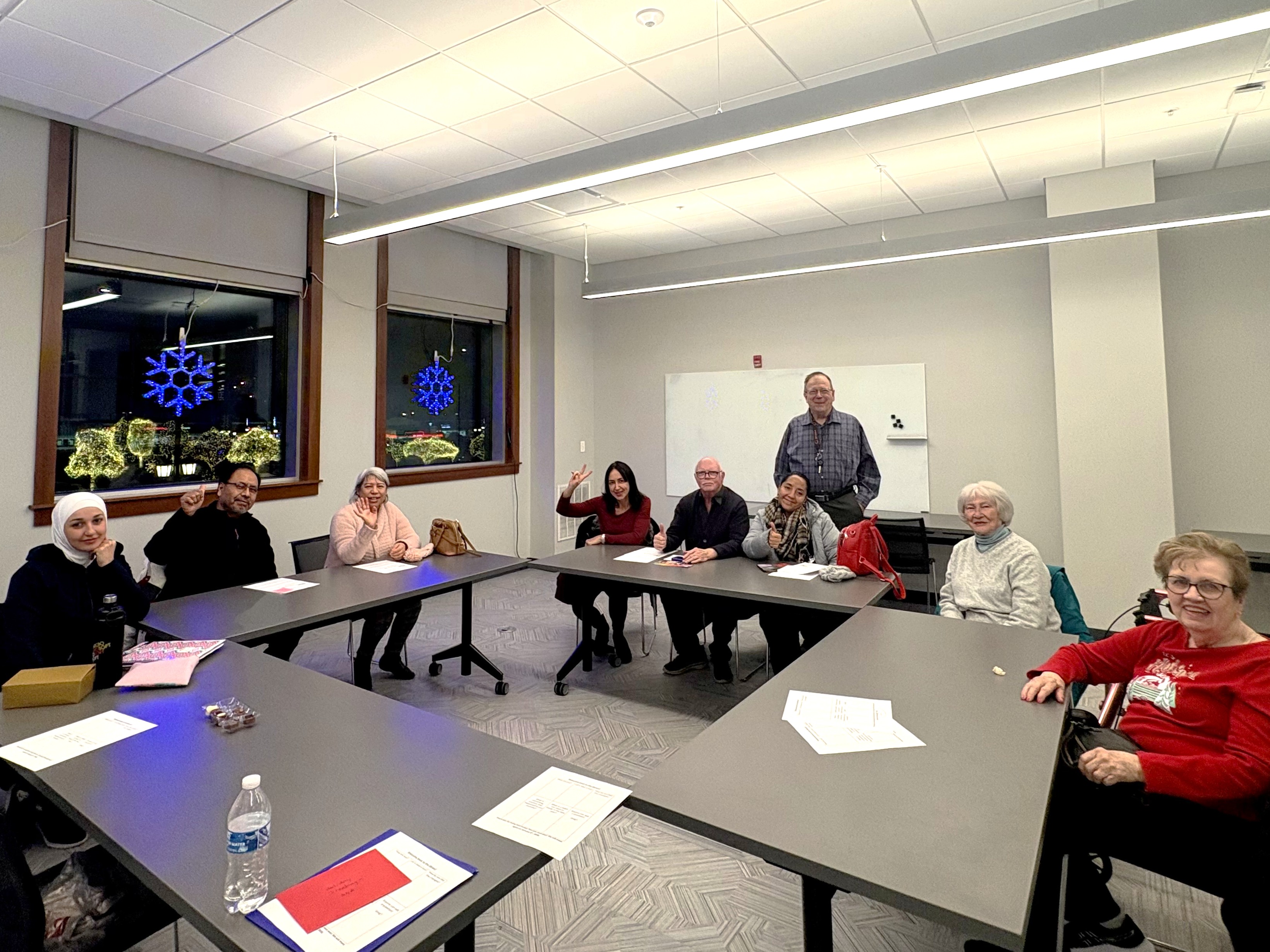 a group of nine people sit around a large table