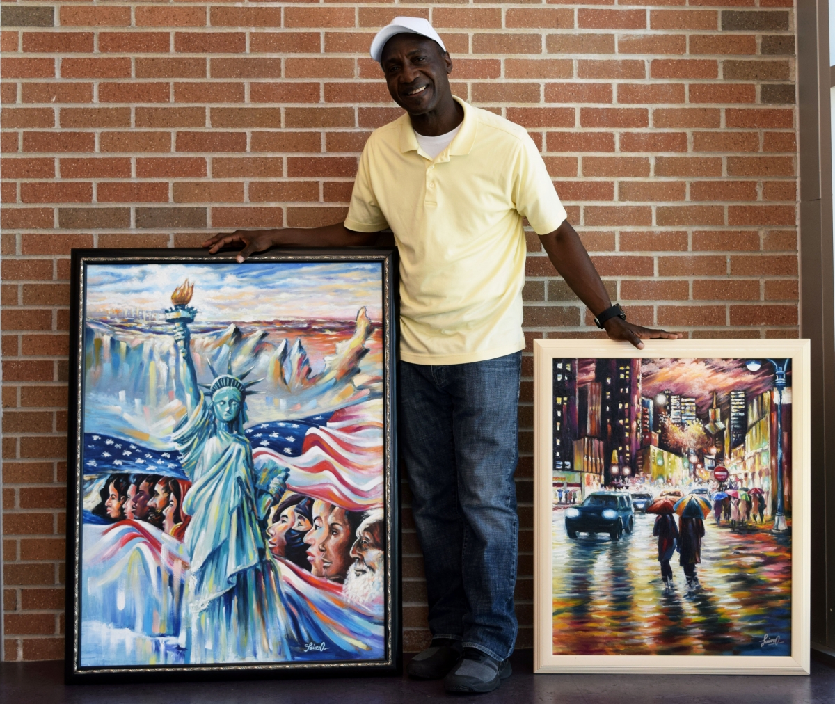 Taiwo Owoniyi poses with two of his original paintings