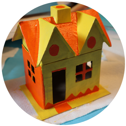 Photo shows a paper mache house painted yellow and orange