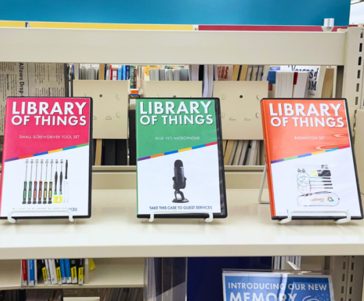 three plastic cases on display on a shelf, labeled Library of Things