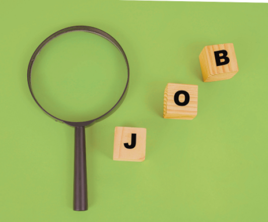 a magnifying glass next to three small wooden blocks with the letters "J" "O" "B"