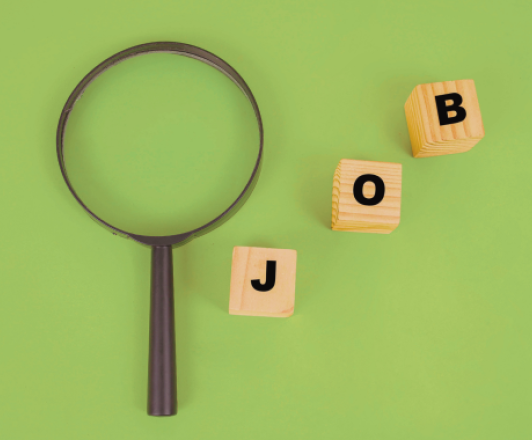 a magnifying glass next to three small wooden blocks with the letters "J" "O" "B"